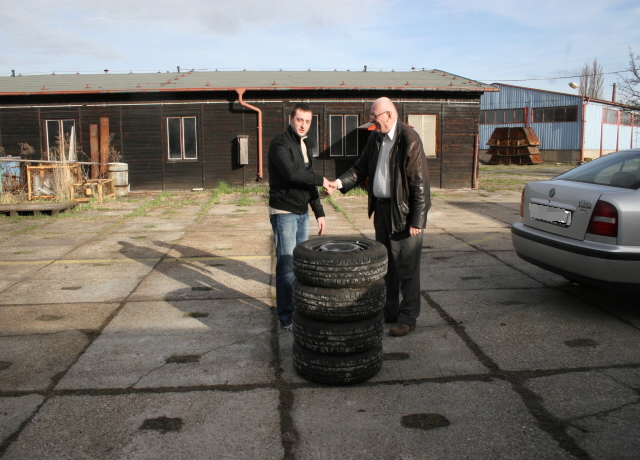 policista (vlevo) předává šťastnému majiteli zajištěné pneumatiky